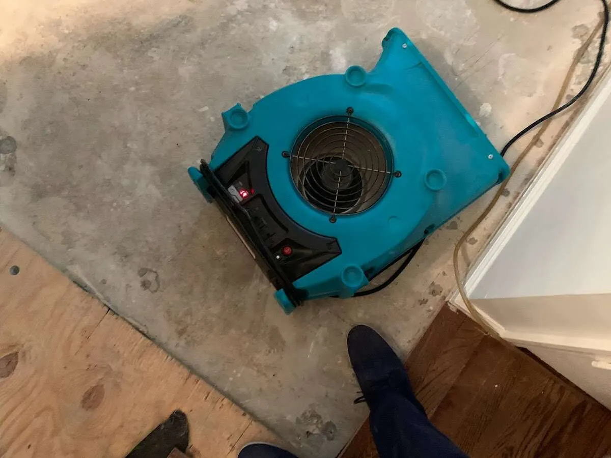 Air mover drying subfloor during Leak Detection & Repair in Colby